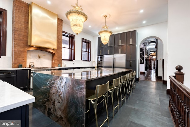 kitchen with a breakfast bar, pendant lighting, high quality appliances, backsplash, and a center island