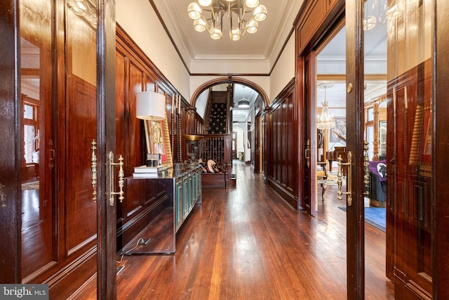 hall featuring dark hardwood / wood-style floors, an inviting chandelier, and french doors