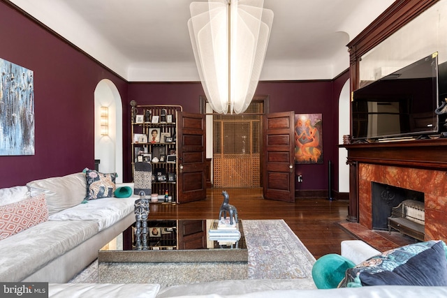 living room featuring dark wood-type flooring and a high end fireplace