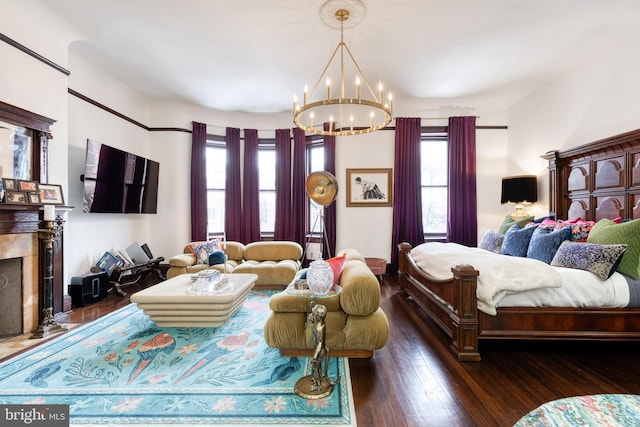 bedroom featuring a notable chandelier, a high end fireplace, and dark hardwood / wood-style floors