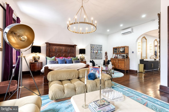 bedroom featuring dark hardwood / wood-style floors, a wall mounted AC, and a notable chandelier