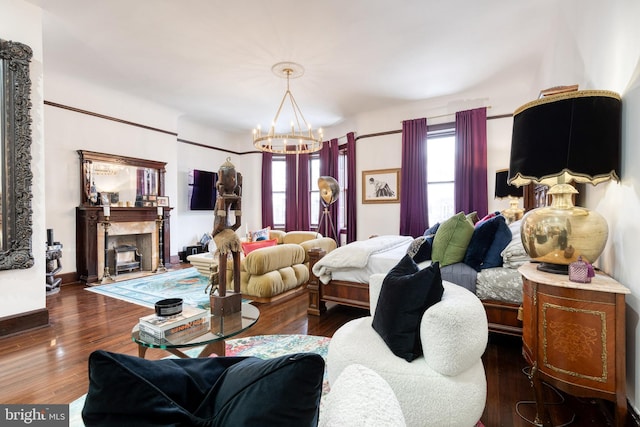 bedroom featuring dark hardwood / wood-style flooring, a premium fireplace, and an inviting chandelier