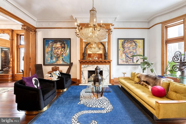 living room featuring dark hardwood / wood-style flooring, crown molding, a high end fireplace, and a chandelier