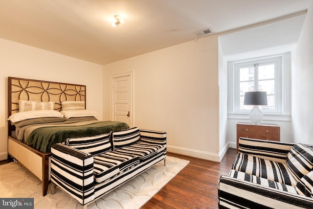 bedroom with dark hardwood / wood-style flooring