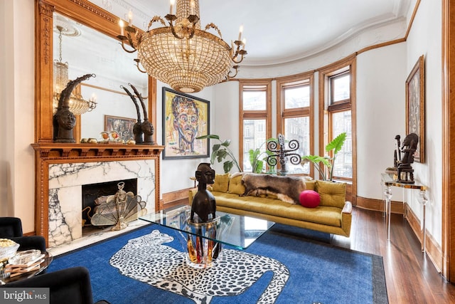 living room with an inviting chandelier, crown molding, a fireplace, and dark hardwood / wood-style floors