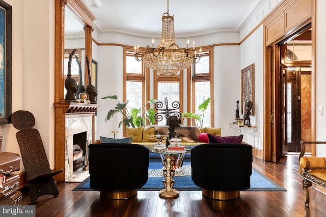 sitting room featuring crown molding, wood-type flooring, a chandelier, and a high end fireplace