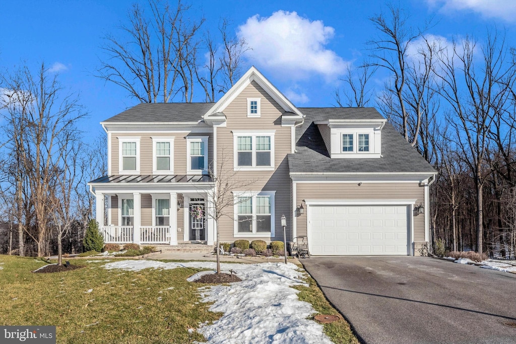 view of front of home featuring a garage, a front yard, and a porch