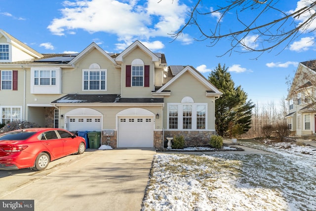 view of front of property with a garage and solar panels