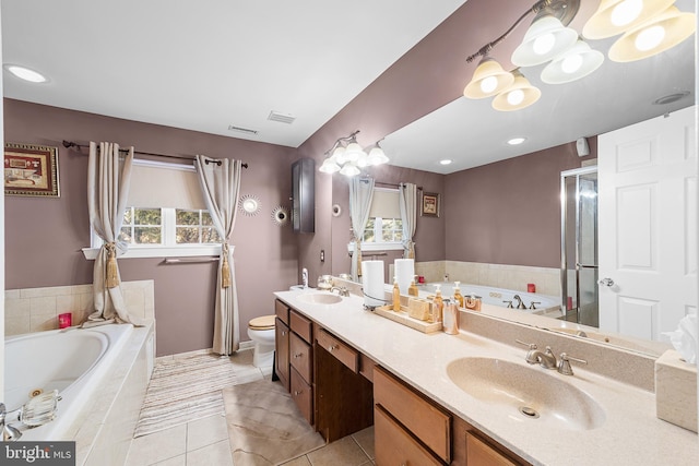 bathroom featuring tiled bath, tile patterned flooring, vanity, and toilet