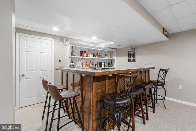 bar with a drop ceiling and light carpet