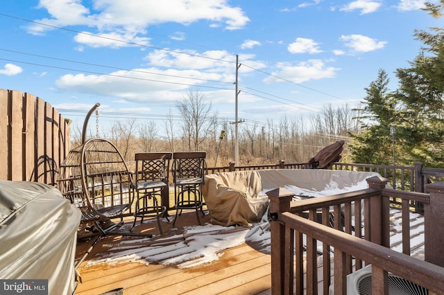 wooden terrace with a grill and cooling unit