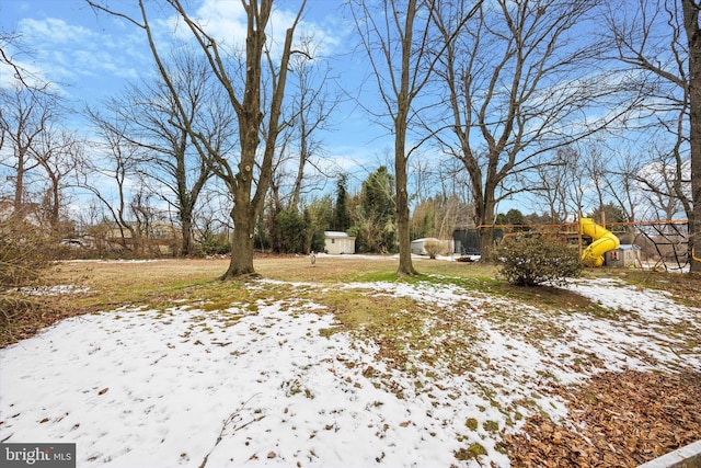 yard covered in snow with a playground