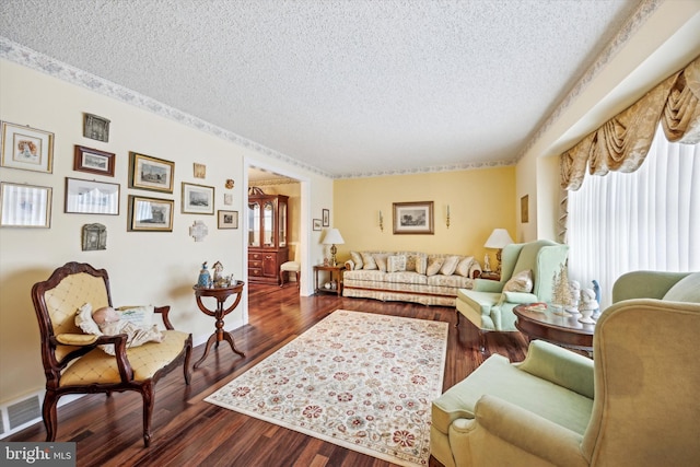 living room with a textured ceiling and dark wood-type flooring