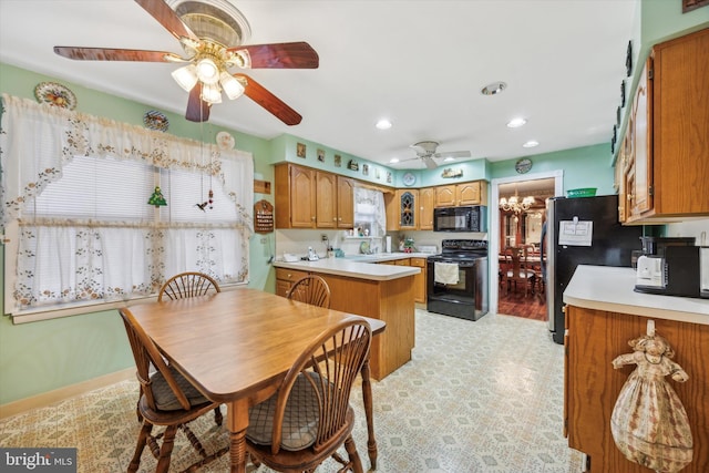 kitchen featuring kitchen peninsula, sink, black appliances, and ceiling fan with notable chandelier