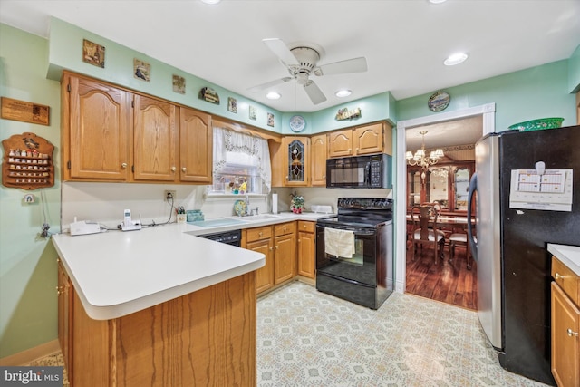 kitchen featuring kitchen peninsula, sink, black appliances, and ceiling fan with notable chandelier