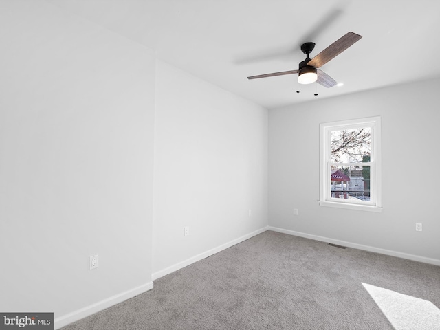 carpeted spare room with ceiling fan