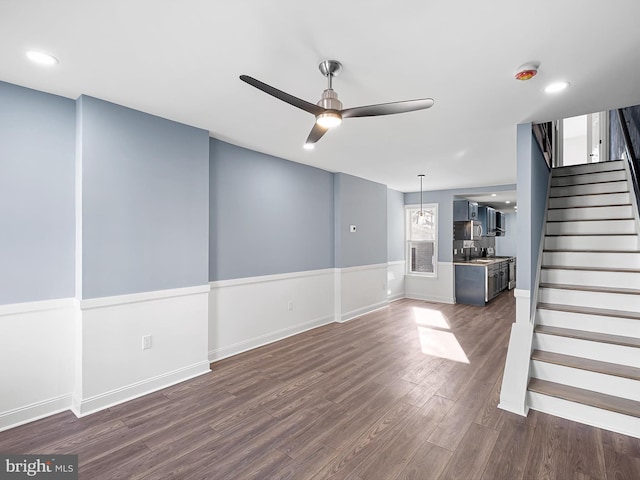 unfurnished living room featuring ceiling fan, sink, and dark wood-type flooring