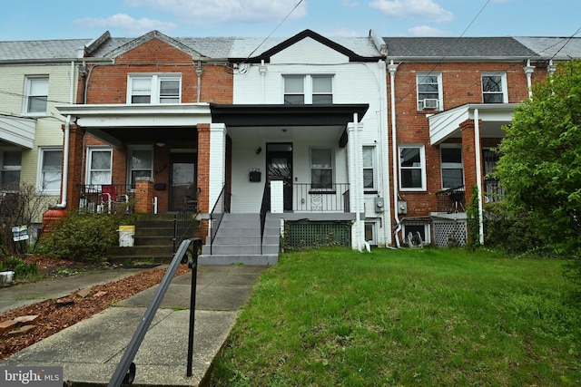 townhome / multi-family property with a porch and a front yard