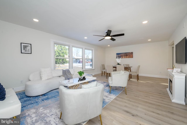 living room featuring light hardwood / wood-style floors and ceiling fan