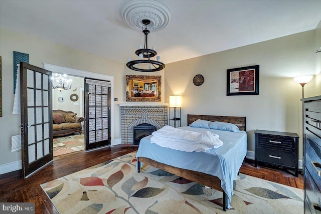 bedroom with a fireplace and dark hardwood / wood-style flooring