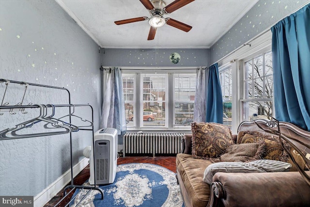 bedroom featuring crown molding, ceiling fan, radiator heating unit, and wood-type flooring