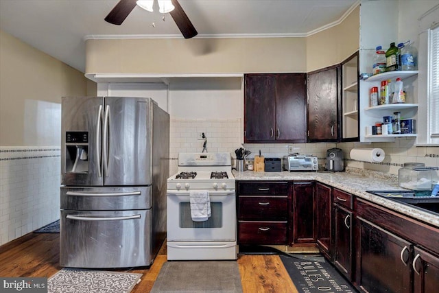 kitchen with hardwood / wood-style floors, stainless steel refrigerator with ice dispenser, ceiling fan, decorative backsplash, and white gas stove