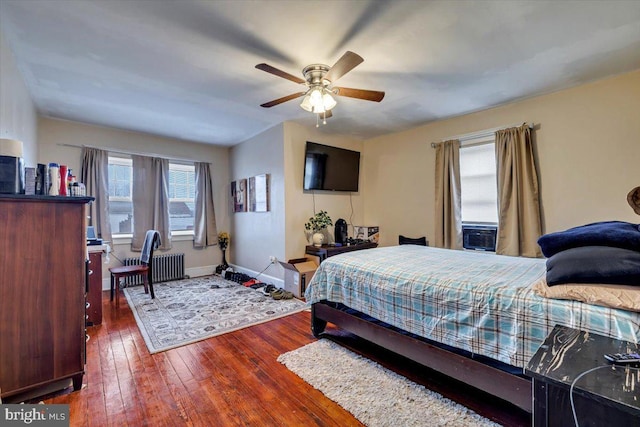 bedroom with ceiling fan, radiator heating unit, and dark wood-type flooring