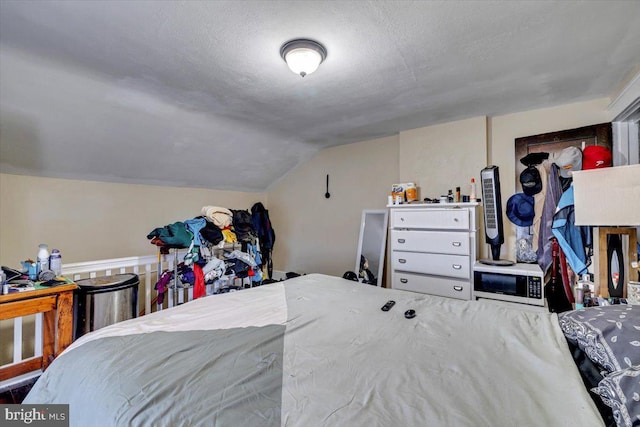 bedroom with a textured ceiling and lofted ceiling