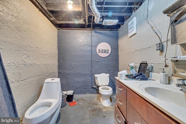 bathroom with concrete flooring, vanity, and toilet