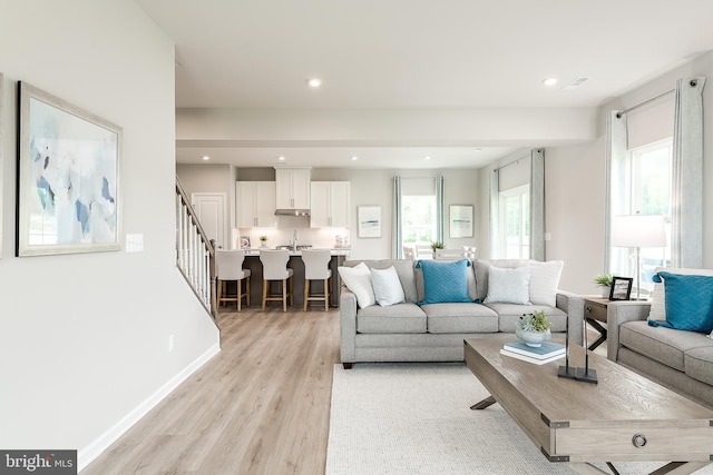 living room featuring sink and light hardwood / wood-style floors