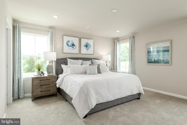 carpeted bedroom featuring multiple windows