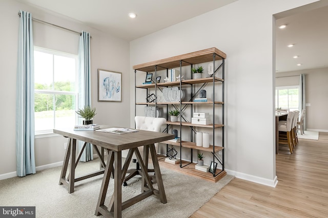 office with plenty of natural light and light hardwood / wood-style flooring