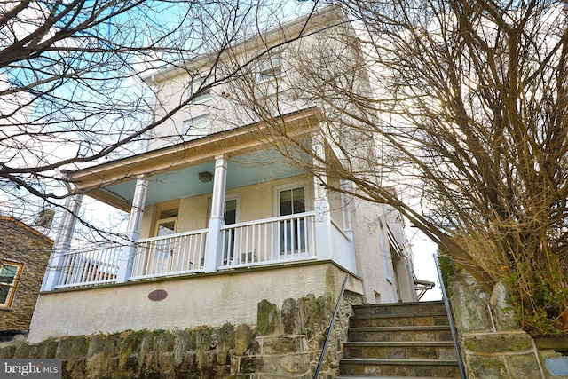 view of home's exterior with a porch and stucco siding