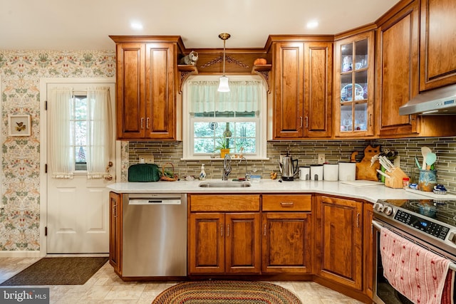 kitchen featuring stainless steel appliances, sink, pendant lighting, and backsplash