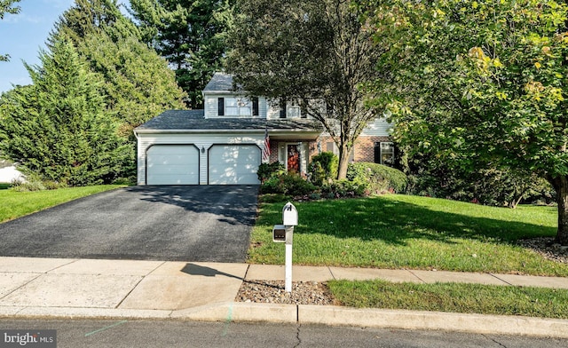 view of front of home with a garage and a front lawn