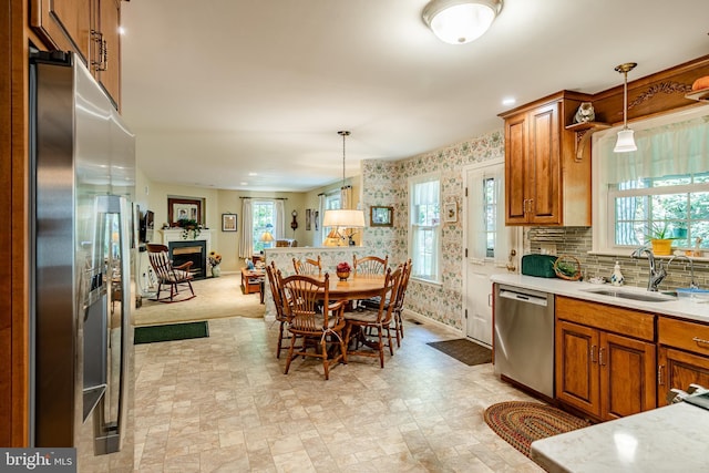 kitchen featuring appliances with stainless steel finishes, decorative light fixtures, and sink