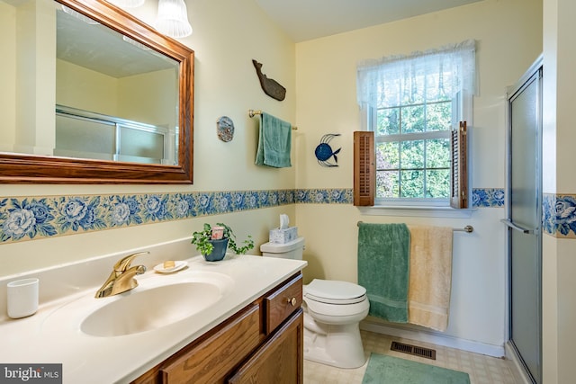 bathroom featuring vanity, toilet, and an enclosed shower