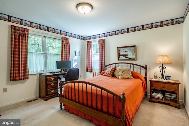 bedroom featuring light colored carpet and multiple windows