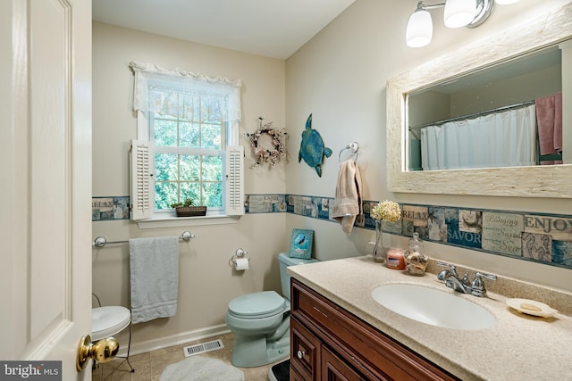 bathroom featuring tile patterned flooring, vanity, and toilet