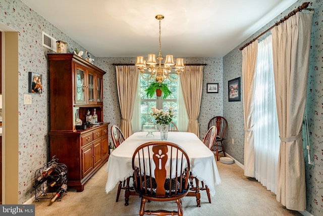 dining area featuring light colored carpet and an inviting chandelier