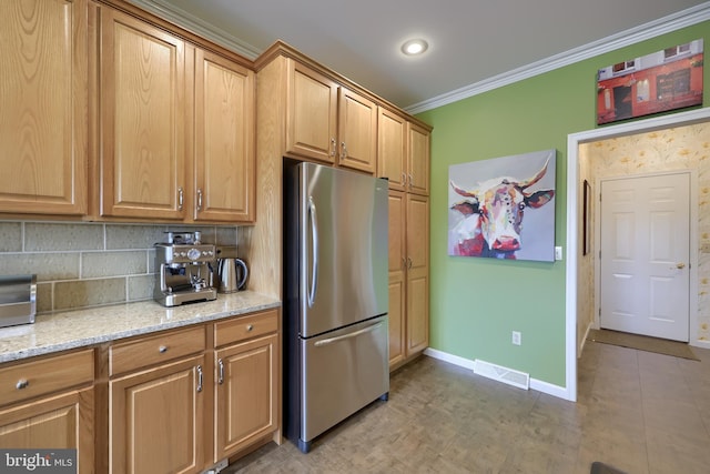 kitchen featuring decorative backsplash, stainless steel fridge, light stone countertops, and crown molding