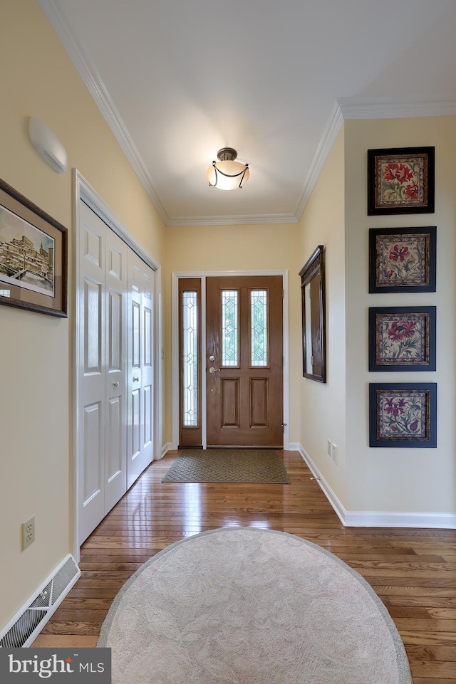 foyer entrance featuring wood-type flooring and ornamental molding