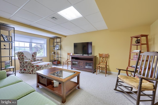 carpeted living room with a paneled ceiling