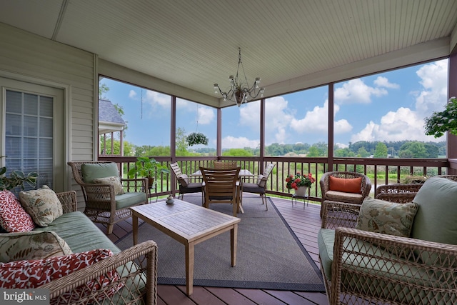 sunroom featuring plenty of natural light and an inviting chandelier