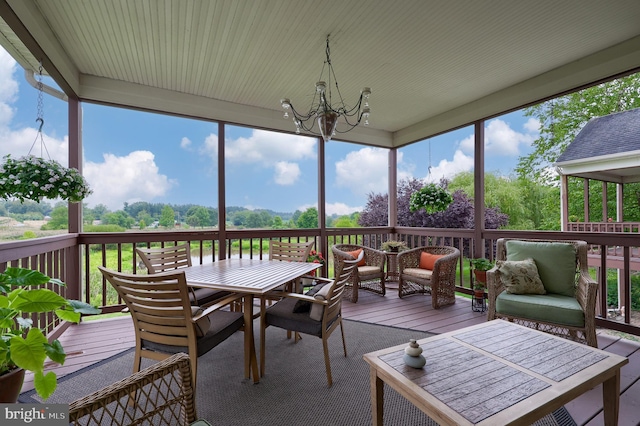 sunroom / solarium featuring an inviting chandelier