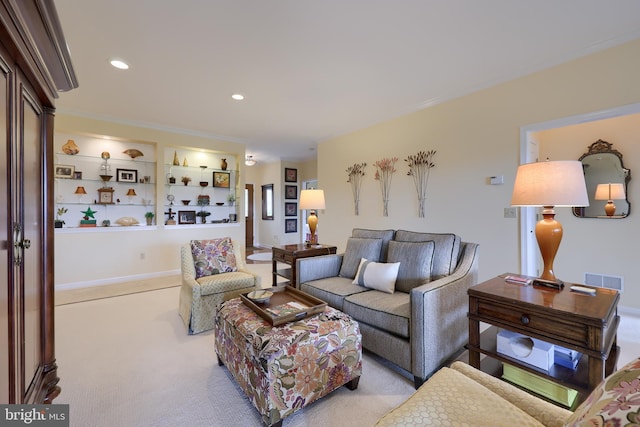 living room with built in features, light colored carpet, and ornamental molding