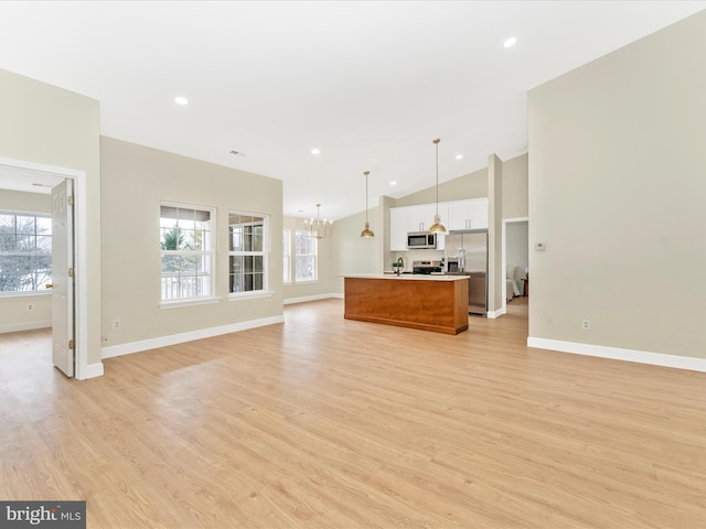 unfurnished living room featuring light hardwood / wood-style floors, vaulted ceiling, and a notable chandelier