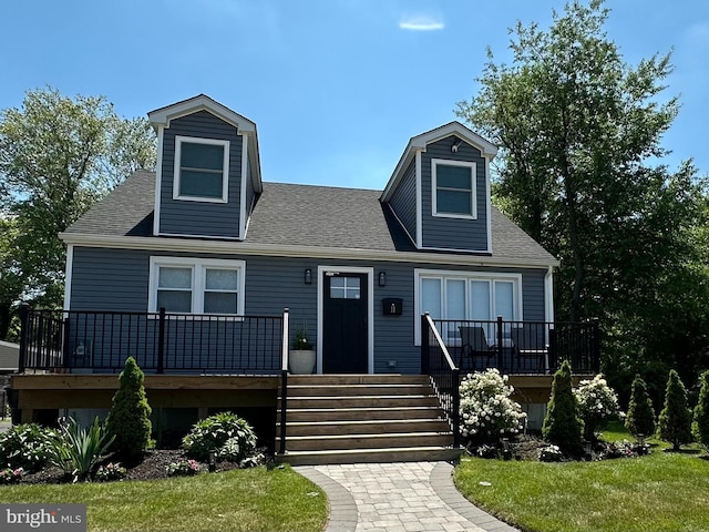 cape cod home featuring a front lawn