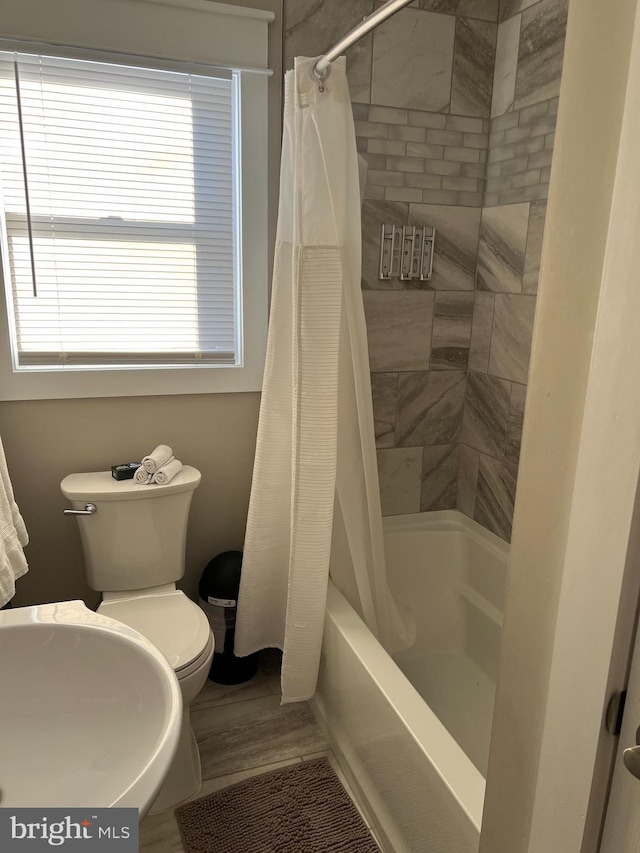 full bathroom featuring sink, shower / bath combination with curtain, hardwood / wood-style flooring, and toilet