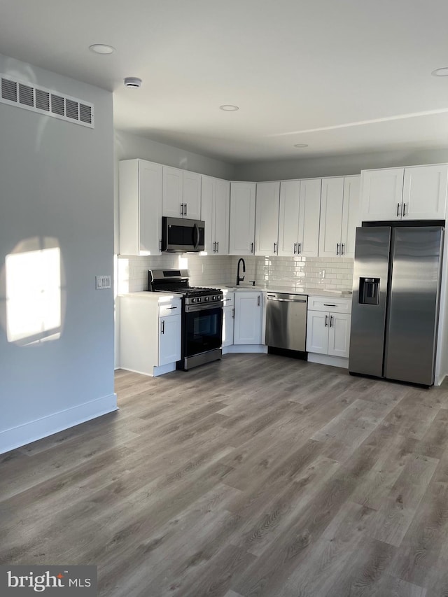 kitchen featuring white cabinets, sink, light wood-type flooring, and stainless steel appliances